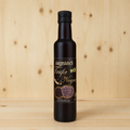 Aceite de trufa negra, etiqueta frontal, sin reflejos, sobre fondo de pino claro