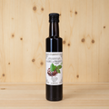 Aceite de oliva virgen extra aromatizado con Laurel y Pimienta negra AGRISANZ, vista trasera cuadrada con el fondo de madera habitual
