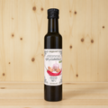 Botella de aceite de oliva virgen extra con ajo y guindilla BIO de AGRISANZ, etiqueta frontal, sobre fondo de madera de pino